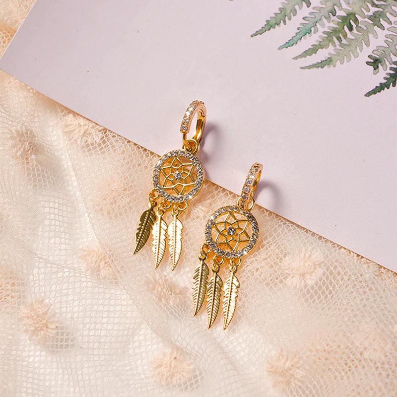 Guld drømmefangerøreringe i 14K med skinnende krystaller og elegante fjer. Et must-have for kvinder.