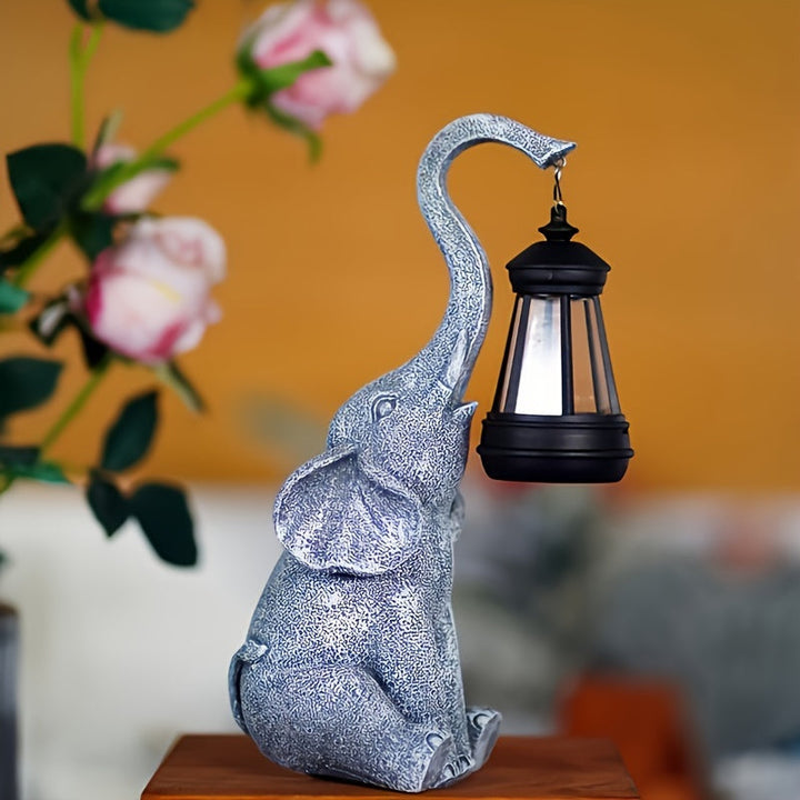 Oplyst elefant solarlampe i skumringen. Skaber varm og indbydende udendørs belysning i haven.