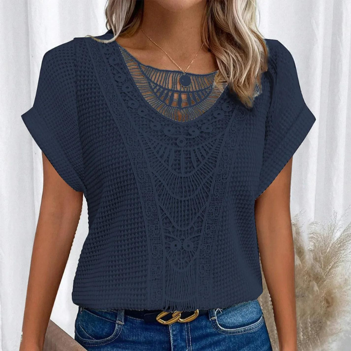 Stilfuld blonde top med feminine detaljer, en trendy tilføjelse til kvindemode.