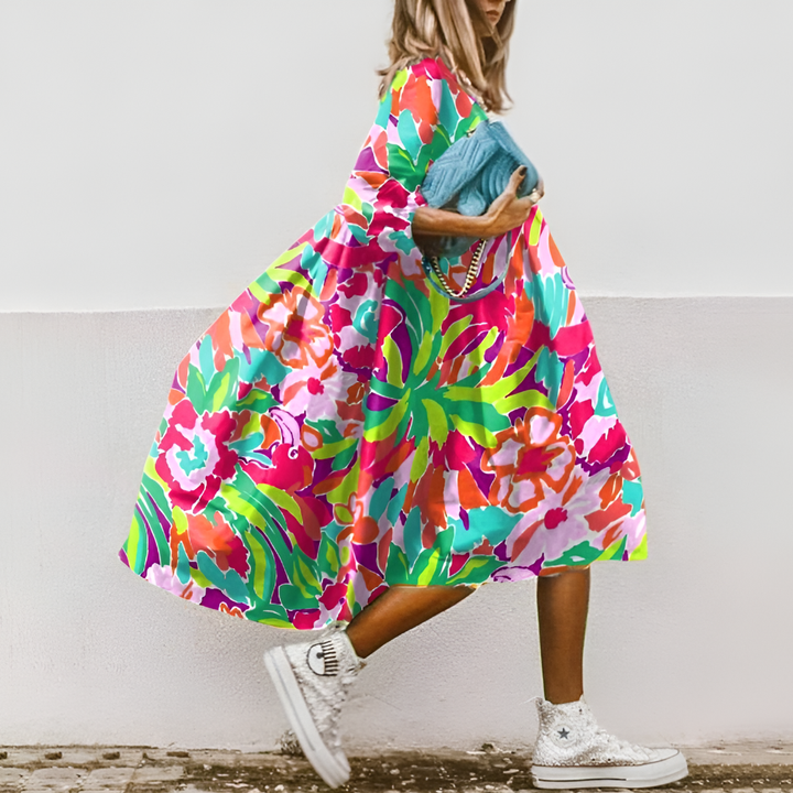 Smuk damekjole i midi-længde med farverigt blomsterprint og stilfulde pufærmer for et elegant look.