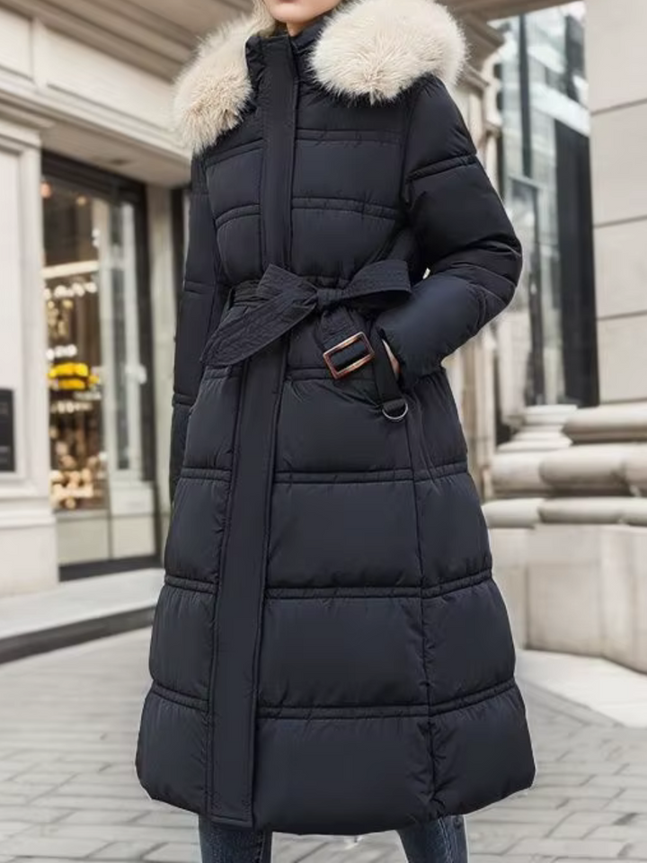 Komfortabel lang kvindefrakke. Elegant pufferfrakke med varmt for og smuk kunstpels krave til vinter.
