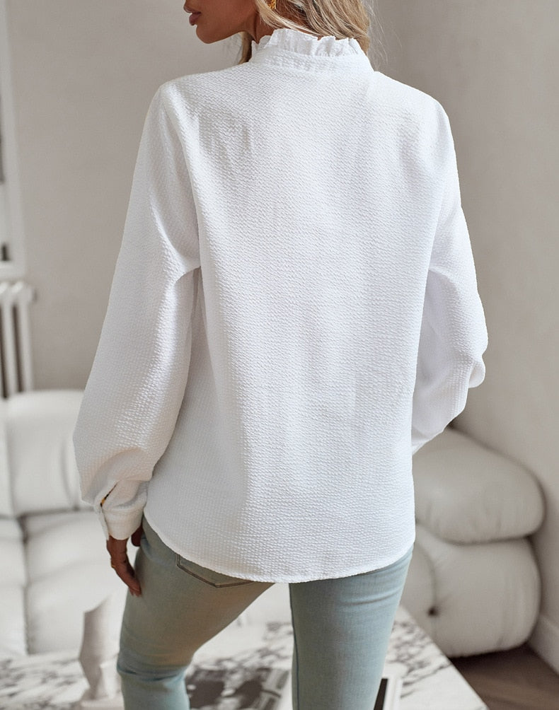 Stilfuld top til kvinder med fine flæsedetaljer og praktiske knapper. Komfortabel og chic.