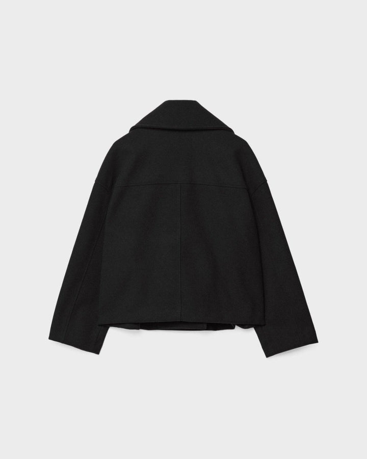 Nærbillede af dobbeltbrystet kvindejakkes front med knapper, elegant blazer detalje.