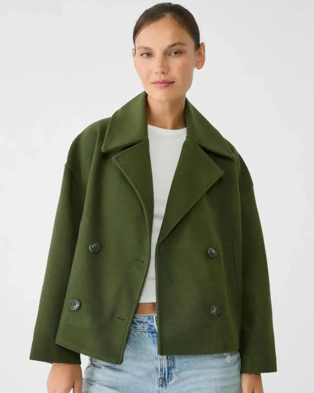 Elegant dobbeltbrystet kort jakke styliseret med tilbehør, komplet mode outfit.