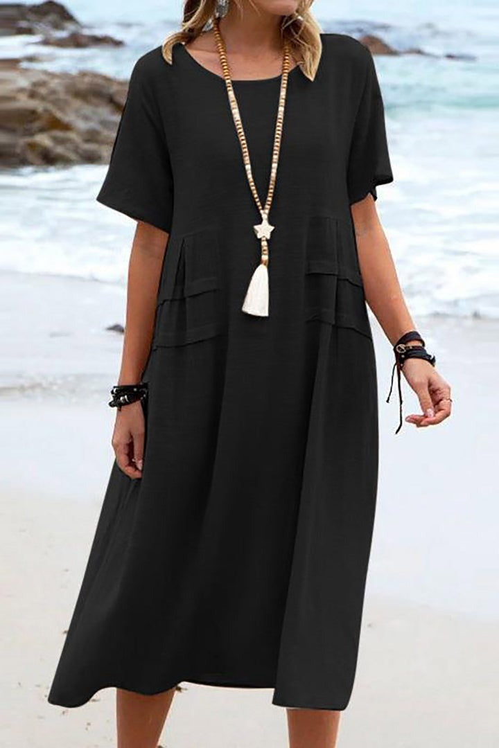 Feminine, ensfarvet dame sommerkjole med rund hals. Elegant og luftig komfort til både hverdag og fest.