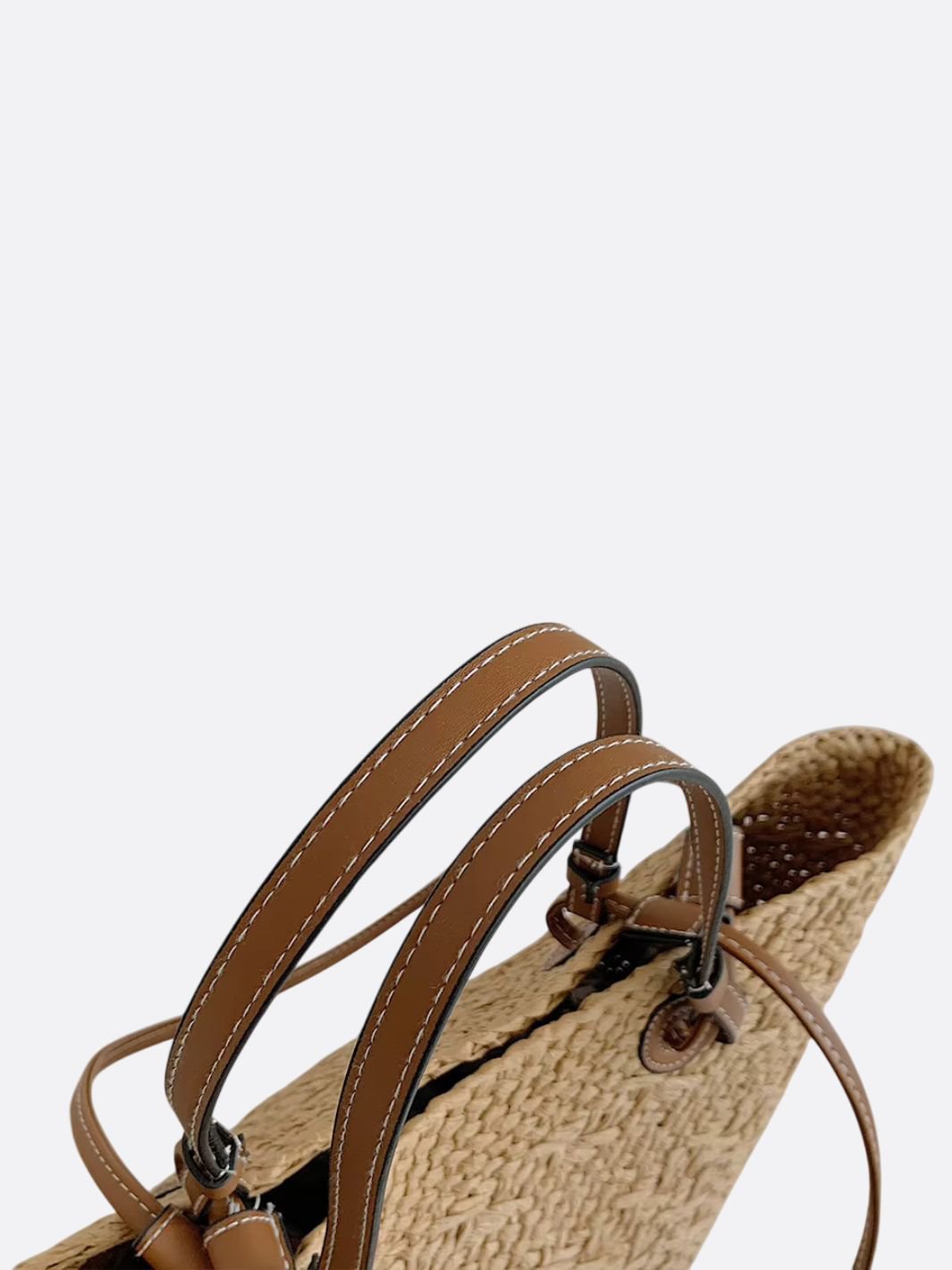 Alsidig beige strå og læder håndtaske, der fungerer som både elegant tote og praktisk hverdagstaske.