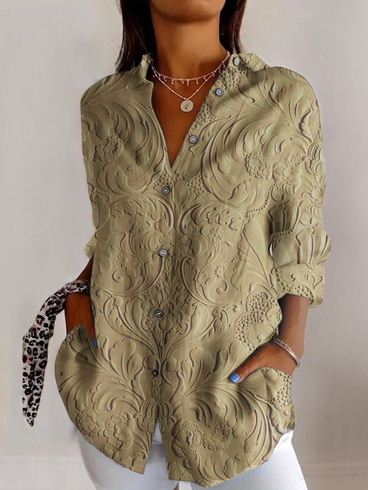 Elegant grøn damebluse med præget blomsterdesign, langærmet og V-udskæring. Perfekt til stilfuld mode.