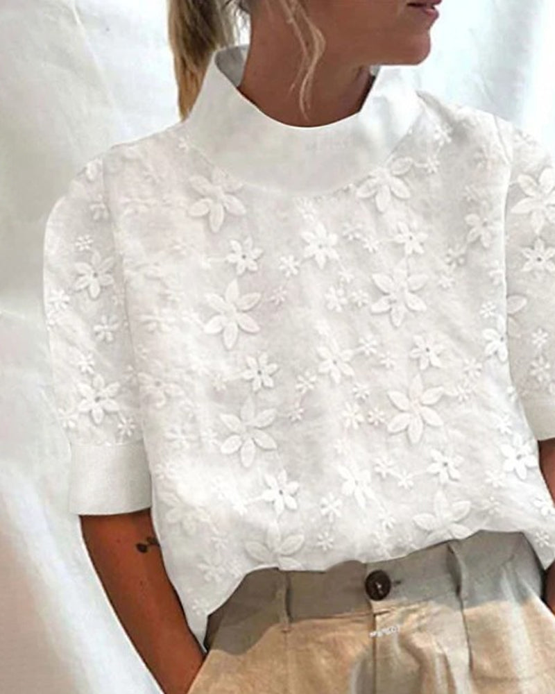 Elegant hvid broderet damebluse med stilfuld ståkrave og halvlangærme, ideel til casual eller arbejdsbrug.