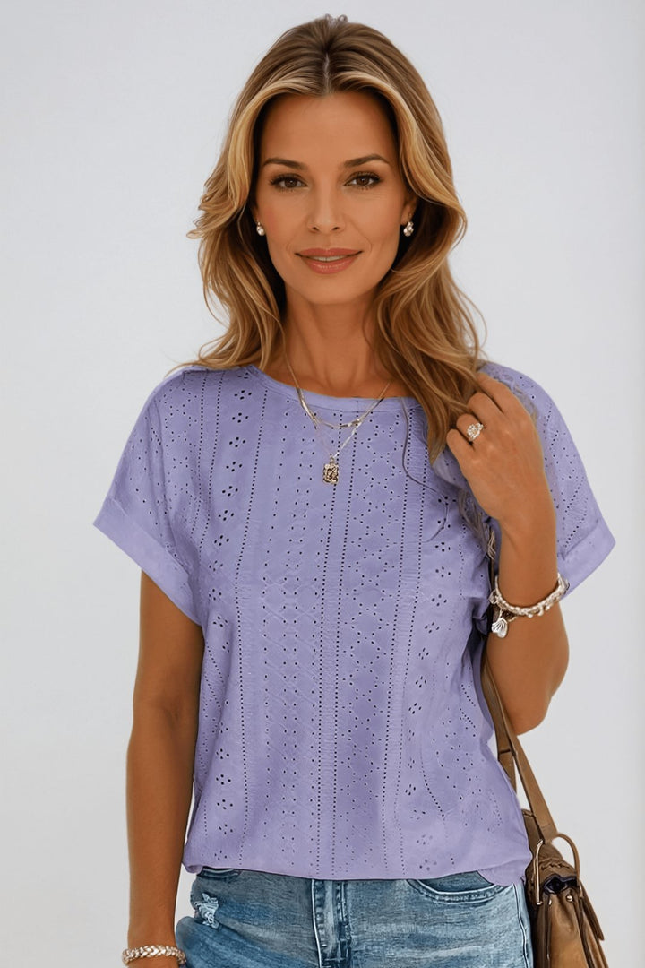 Stilfuld lilla kortærmet damebluse med unikt hulmønster og rund hals. En elegant bomuldsbluse til alle anledninger.