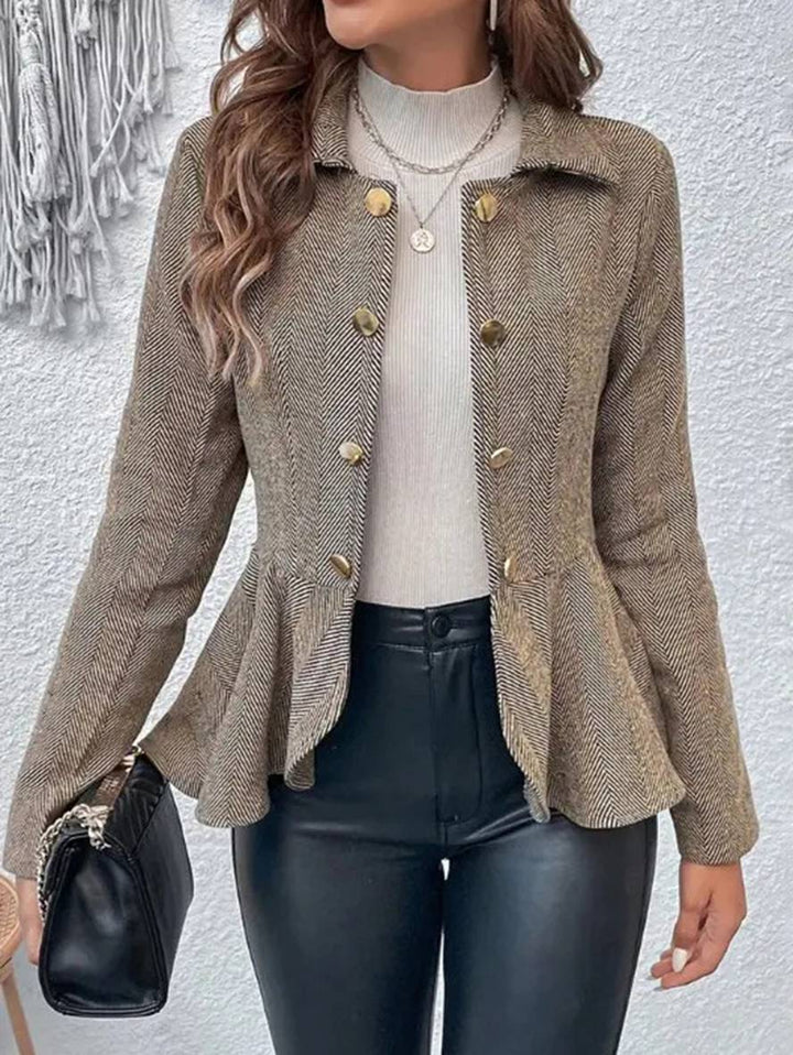 Elegant kort dameblazer med chevron-mønster og peplum-kant i klassisk sort.