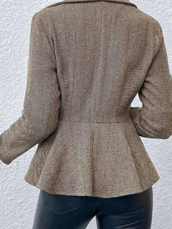 Kvinders korte blazer med peplum, dobbeltradet lukning og unikt chevron-mønster.