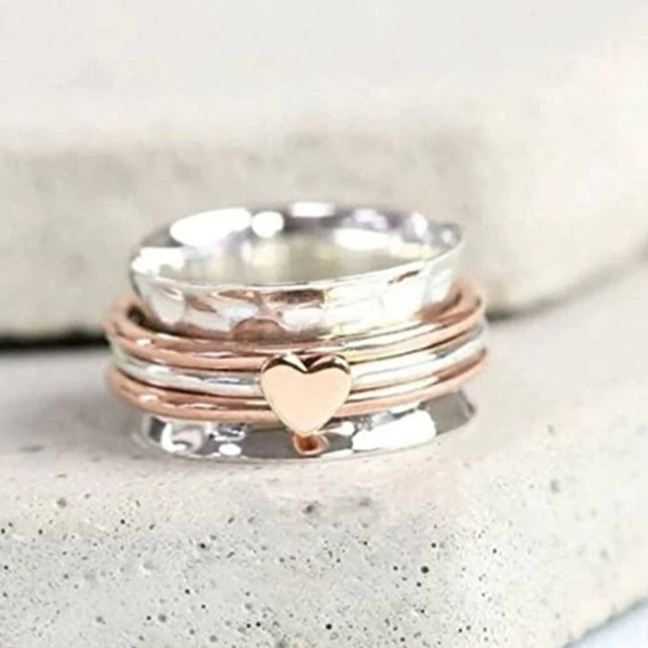 Elegant kvinders roterende hjertering i sølvdesign, perfekt som fidget ring og stresslindring. Stilfuldt smykke.