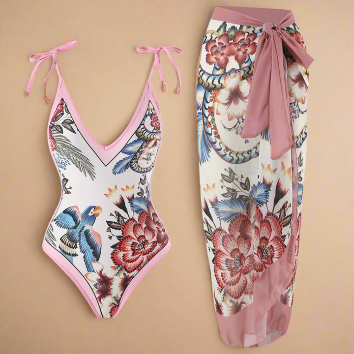 Smukt strandsæt med matchende blomster- og fugleprint pareo. Elegant badetøj til kvinder, klar til pool og sommer.