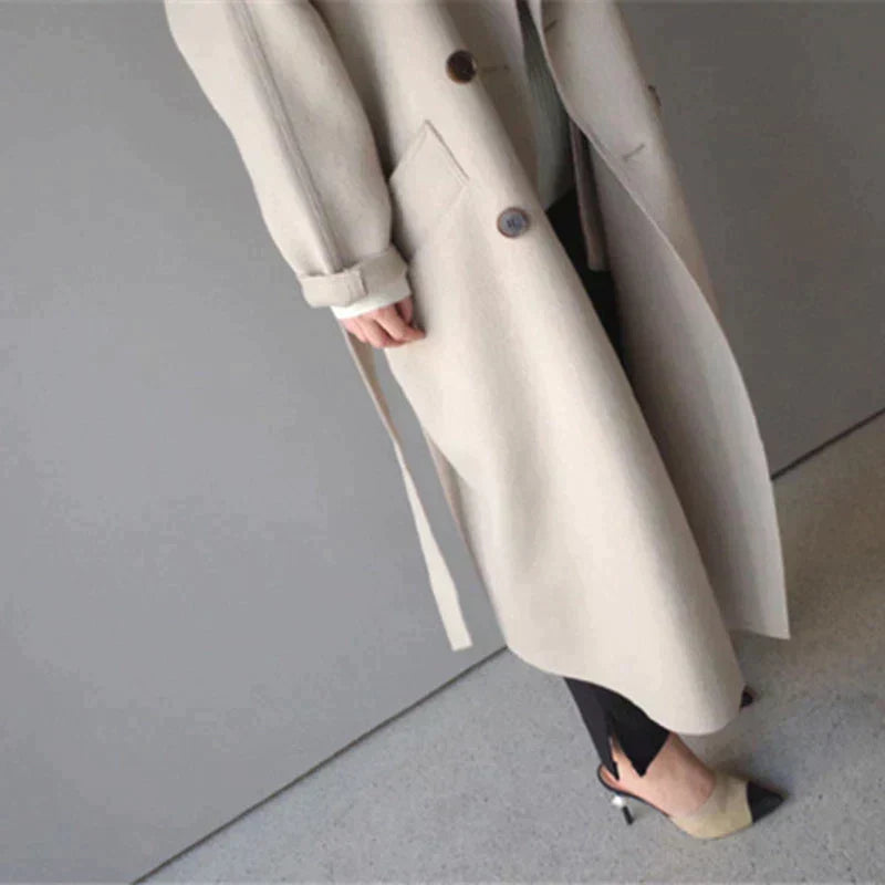 Stilfuld lang beige vinterfrakke til kvinder. Varm damefrakke med elegant snit, ideel til vintermode.