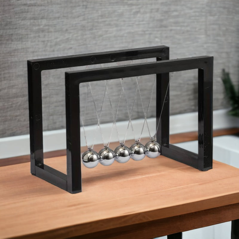 Elegant Newton pendul til skrivebordsdekoration, sort base, stål kugler, symboliserer ro og fokus.