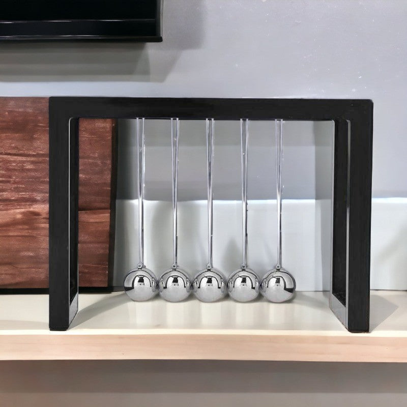 Klassisk Newton pendul i minimalistisk design, videnskabslegetøj og kontorudsmykning, afslappende bevægelse.