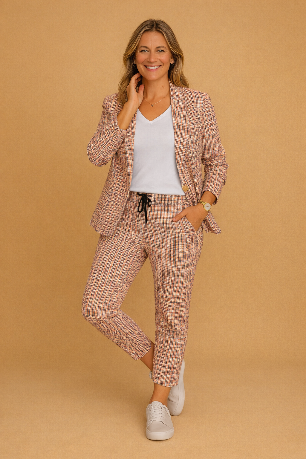 Elegant smart-casual todelt sæt til damer med ternet jakke og matchende bukser i lyserød/grå. Perfekt til kontor.