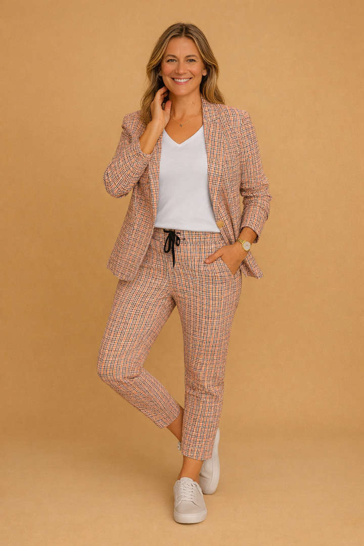 Elegant smart-casual todelt sæt til damer med ternet jakke og matchende bukser i lyserød/grå. Perfekt til kontor.