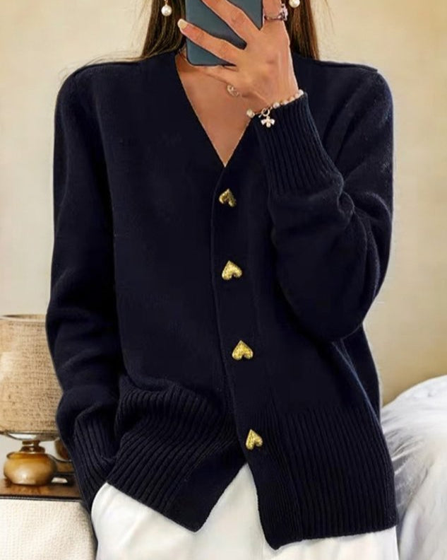Kvinde bærer en elegant strikket cardigan med hjerteknapper. Et komfortabelt og stilfuldt valg til enhver lejlighed.