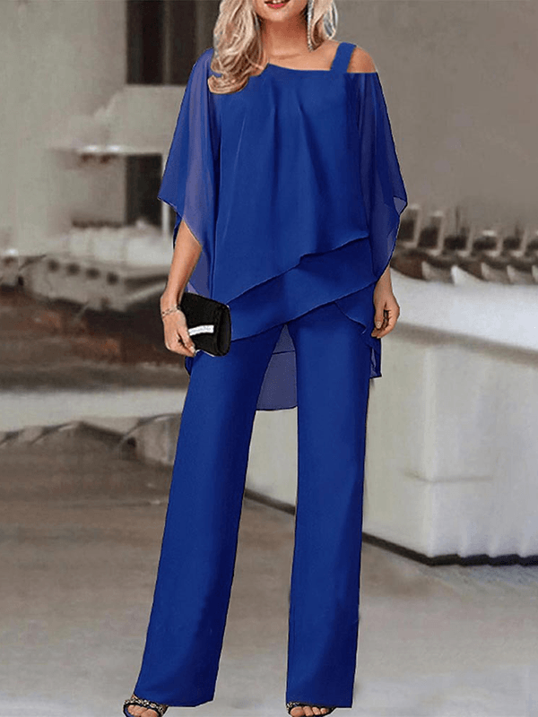 Trendy kvindesæt med unik asymmetrisk top og vide bukser for et elegant og komfortabelt festlook.