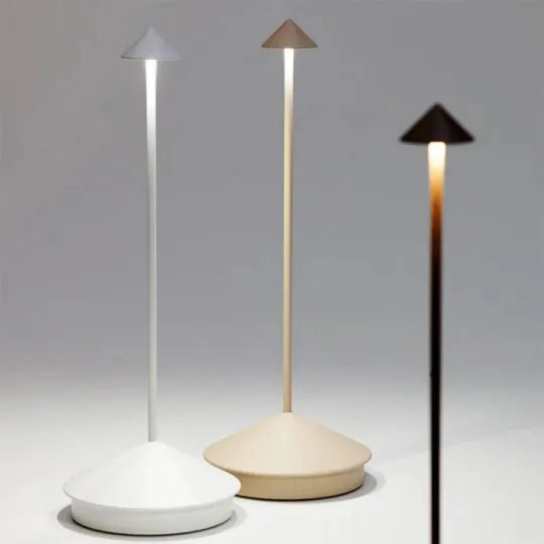 Trådløs bordlampe oplyser et udendørs loungeområde om natten. Viser stemningslys under åben himmel.