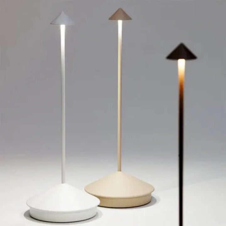 Trådløs bordlampe oplyser et udendørs loungeområde om natten. Viser stemningslys under åben himmel.