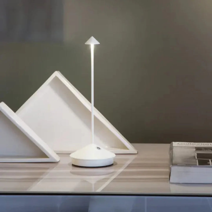 Trådløs bordlampe i dagslys på et havebord. Understreger portabelt design og alsidighed.