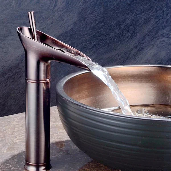 Elegant badeværelsesarmatur med vandfaldseffekt i antik messing finish.