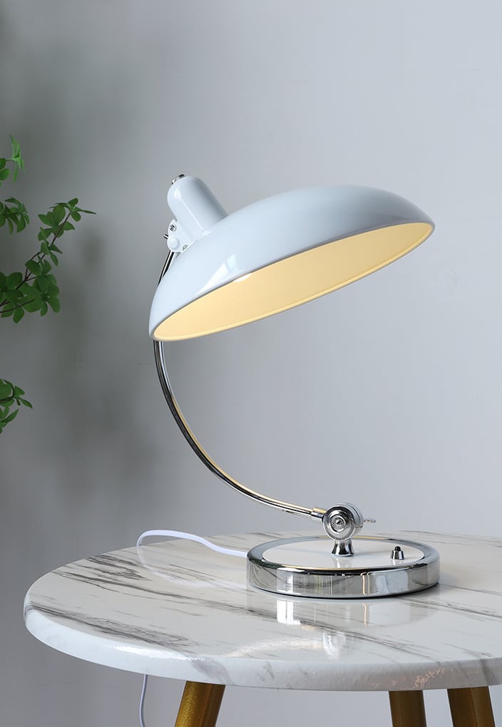 Billede af en grøn Bauhaus bordlampe i metal, fremhæver dens elegante design.