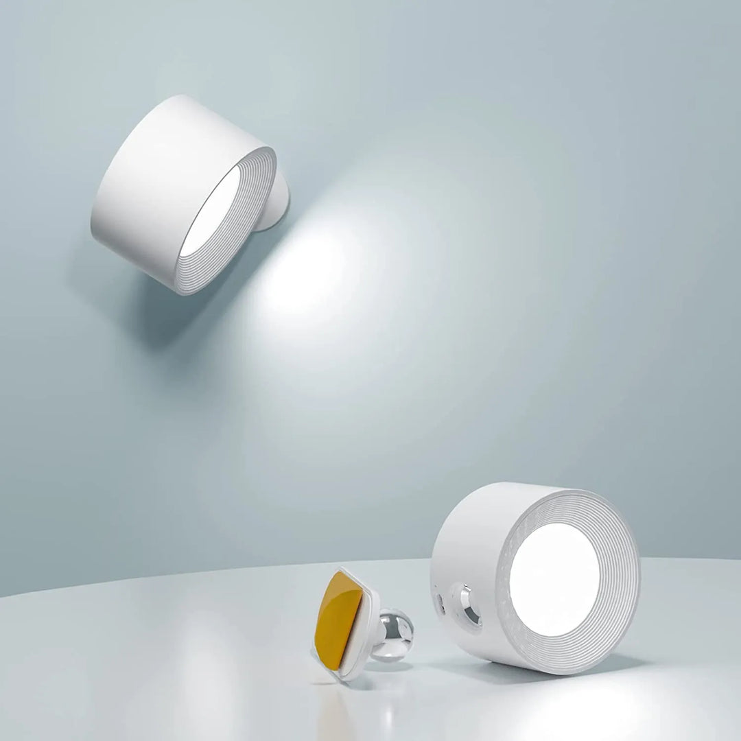 Elegant trådløs væglampe i sort set fra siden, med dæmpbart LED-lys og 360° drejelig funktion for fleksibel positionering.
