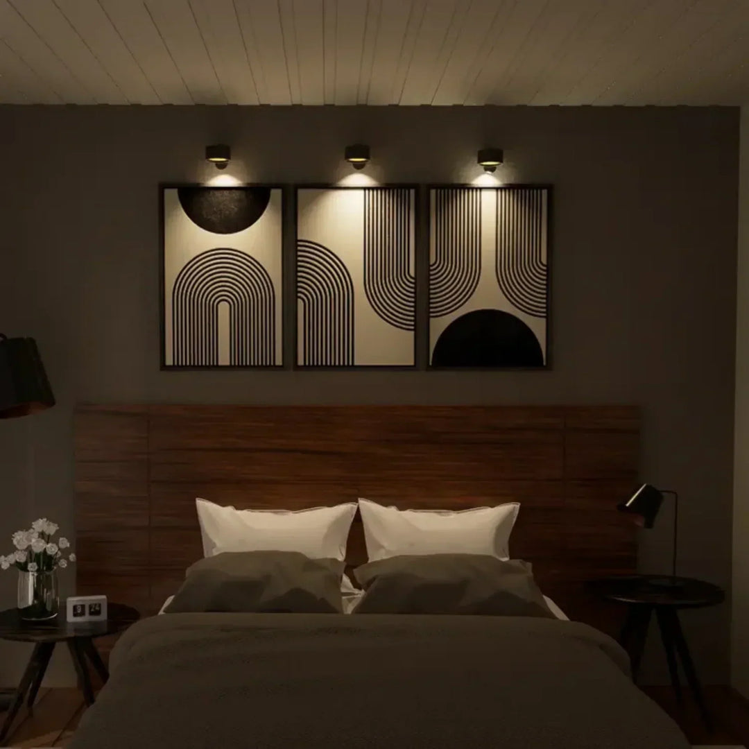 Elegant trådløs væglampe i sort set fra siden, med dæmpbart LED-lys og 360° drejelig funktion for fleksibel positionering.