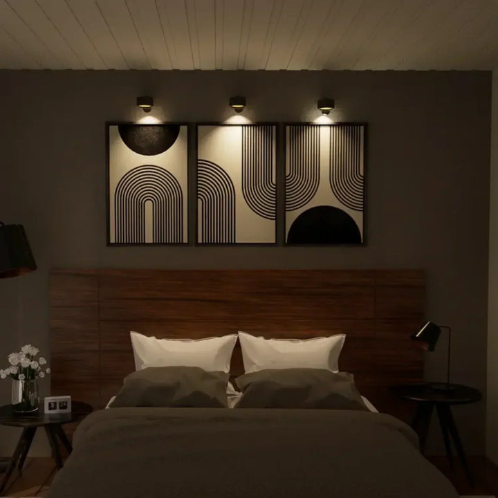 Elegant trådløs væglampe i sort set fra siden, med dæmpbart LED-lys og 360° drejelig funktion for fleksibel positionering.