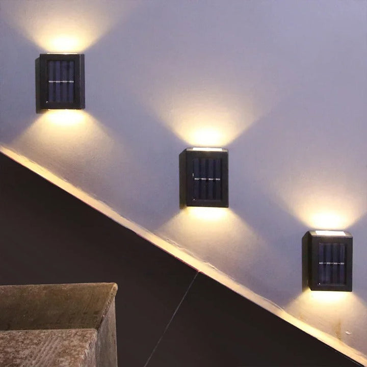 Elegant soldrevet LED-væglampe med varmhvidt lys, vejrbestandig til terrasse og havebelysning.