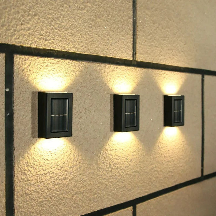 Elegant soldrevet LED-væglampe med varmhvidt lys, vejrbestandig til terrasse og havebelysning.