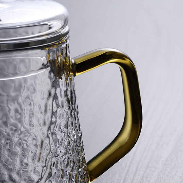 Elegant tekande af hamret, varmebestandigt glas med indbygget si og guldfarvet håndtag. Perfekt til teenydelse.