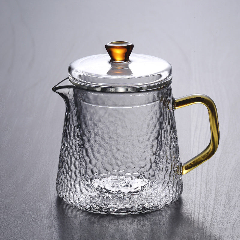 Elegant tekande af hamret, varmebestandigt glas med indbygget si og guldfarvet håndtag. Perfekt til teenydelse.