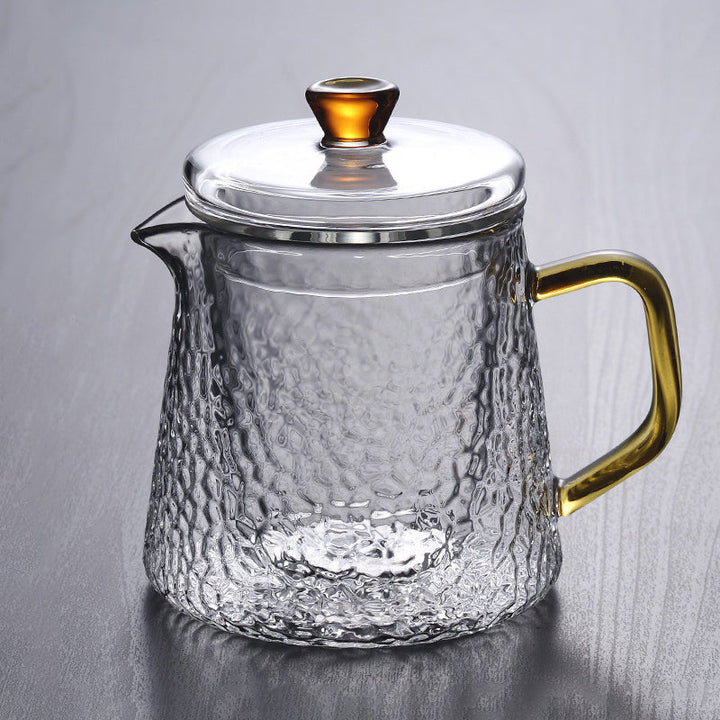 Elegant tekande af hamret, varmebestandigt glas med indbygget si og guldfarvet håndtag. Perfekt til teenydelse.