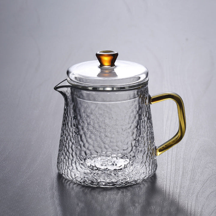Elegant tekande af hamret, varmebestandigt glas med indbygget si og guldfarvet håndtag. Perfekt til teenydelse.
