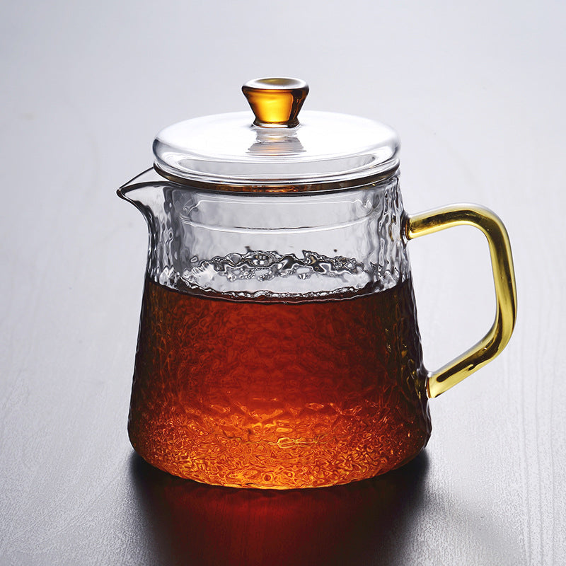 Elegant tekande af hamret, varmebestandigt glas med indbygget si og guldfarvet håndtag. Perfekt til teenydelse.