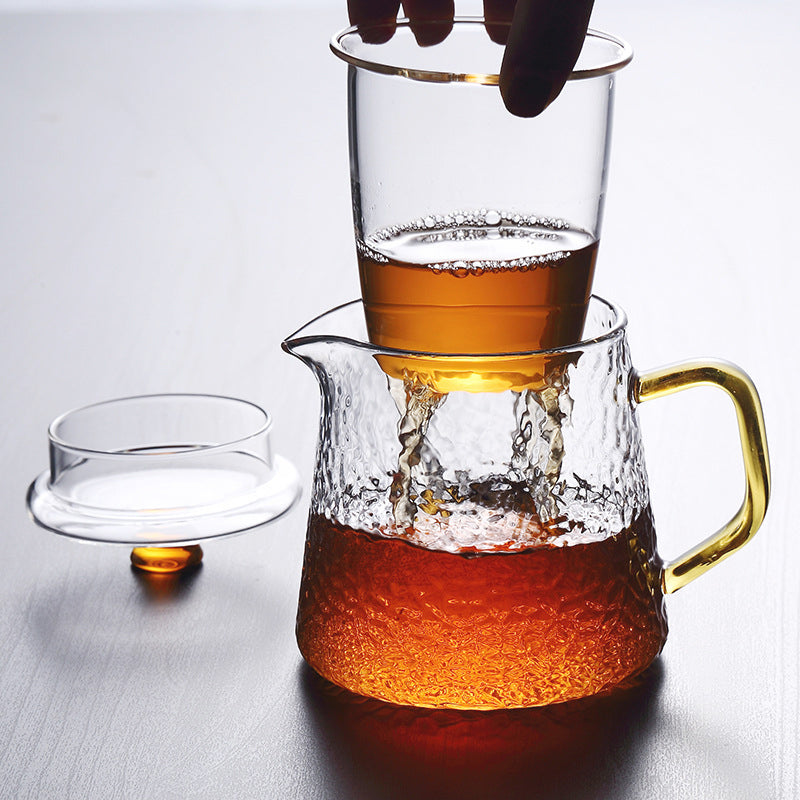 Elegant tekande af hamret, varmebestandigt glas med indbygget si og guldfarvet håndtag. Perfekt til teenydelse.