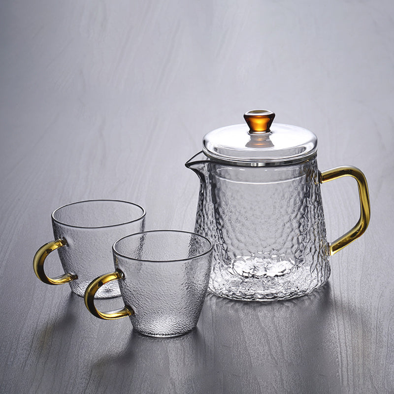 Elegant tekande af hamret, varmebestandigt glas med indbygget si og guldfarvet håndtag. Perfekt til teenydelse.