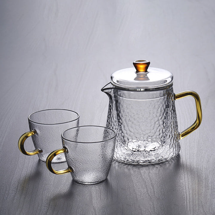 Elegant tekande af hamret, varmebestandigt glas med indbygget si og guldfarvet håndtag. Perfekt til teenydelse.