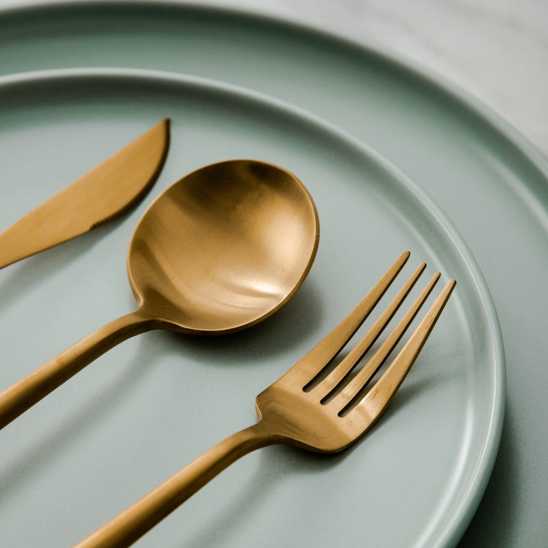 Elegant minimalistisk bestiksæt i rustfrit stål, guldfarvet, med rene linjer til stilfuld borddækning; 20 dele.