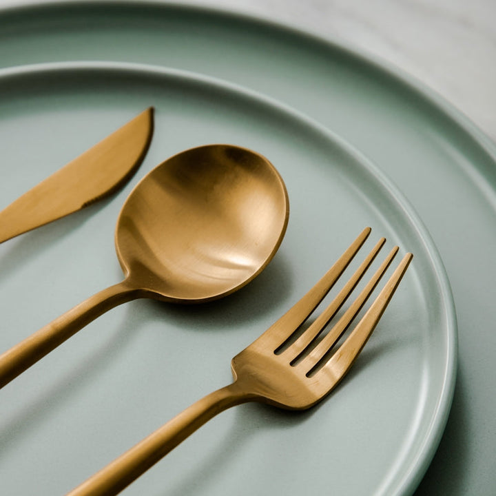 Elegant minimalistisk bestiksæt i rustfrit stål, guldfarvet, med rene linjer til stilfuld borddækning; 20 dele.