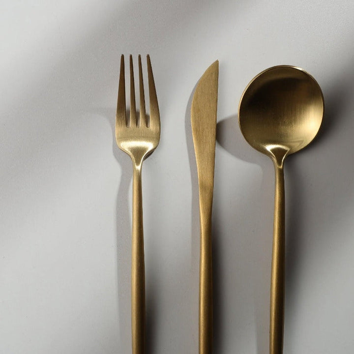 Elegant minimalistisk bestiksæt i rustfrit stål, guldfarvet, med rene linjer til stilfuld borddækning; 20 dele.