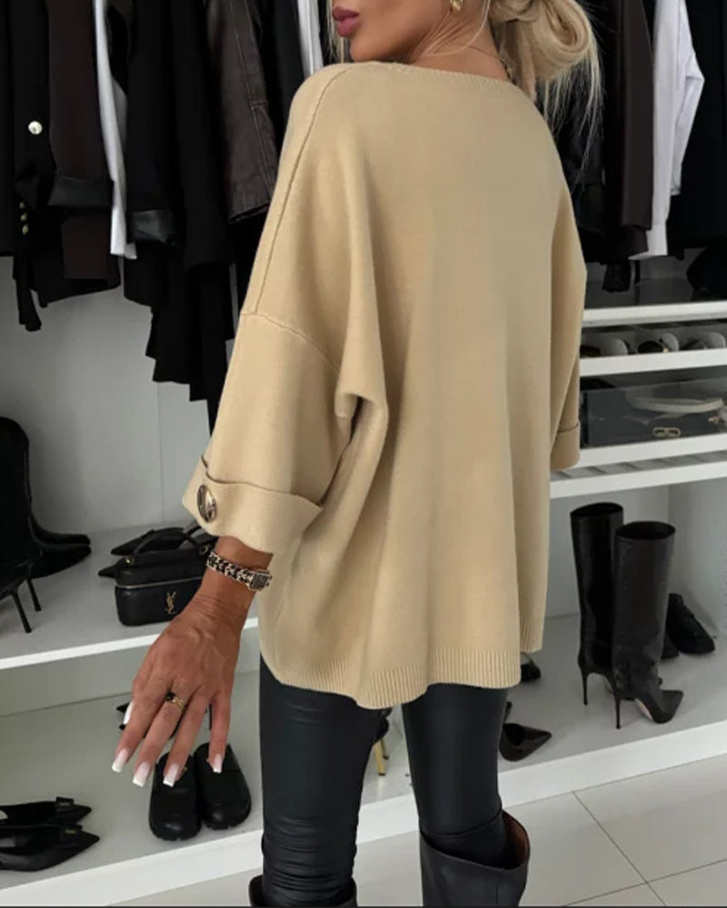 Nærbillede af den moderne knapdetalje på den elegante strikbluse til kvinder.