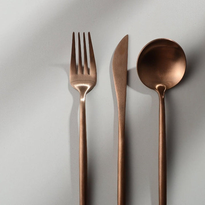 Gyldent bestiksæt i rustfrit stål med elegant minimalistisk design, ideel til moderne borddækninger.