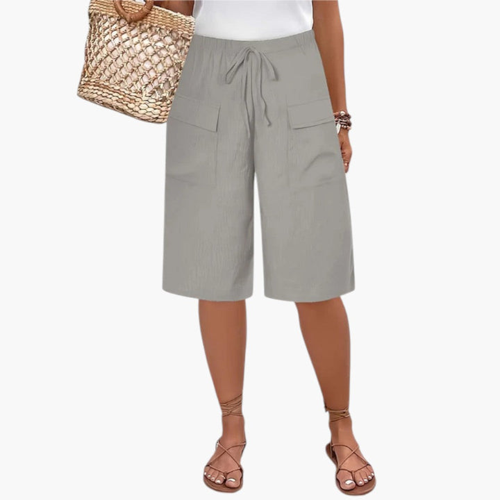 Grå kvinders shorts med elastisk talje, justerbar snor og frontlommer, perfekt til sommer og hverdag.