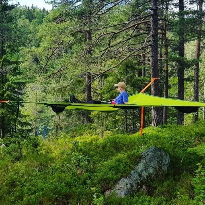 Rummelig grøn flerpersoners hængekøje i skoven til camping og familieeventyr, perfekt til naturoplevelser.