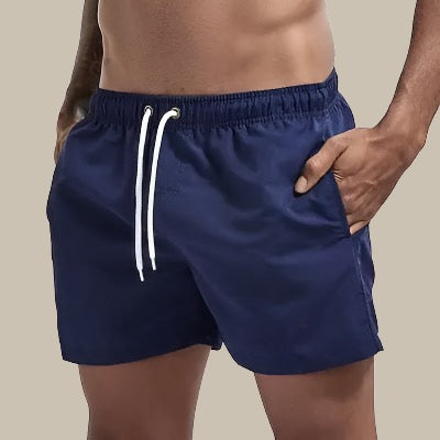 Grønne badeshorts til mænd, hurtigtørrende, elastik i taljen med snøre og lommer, komfortable til strand og pool.